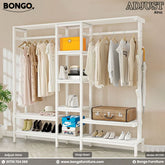 White wardrobe rack with clothes, shoes, and bags on a neutral background