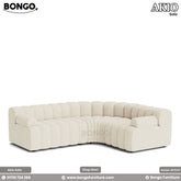 An L-shaped Akio sofa upholstered in beige fabric, featuring a plush design with deep seat cushions and a low-profile structure.