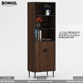 A product image of the "ARCTIC Multipurpose Shelf," a tall and narrow storage tower with a dark wood grain finish. The cabinet has a dark trim and stands on four slim, black legs. The lower half of the unit is a two-door cupboard with small black handles, while the upper half consists of open display shelves. The shelves are styled with decorative items, including books and small vases of flowers. The "BONGO" brand logo is in the top-left corner.
