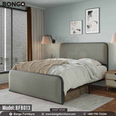 A full size bed with a gray headboard and footboard, featuring a white mattress, placed in a room with nightstands and wall art.