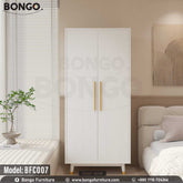A white Jesty cupboard with gold handles, placed in a bedroom setting, part of the furniture collection BFC007 by Bongo.