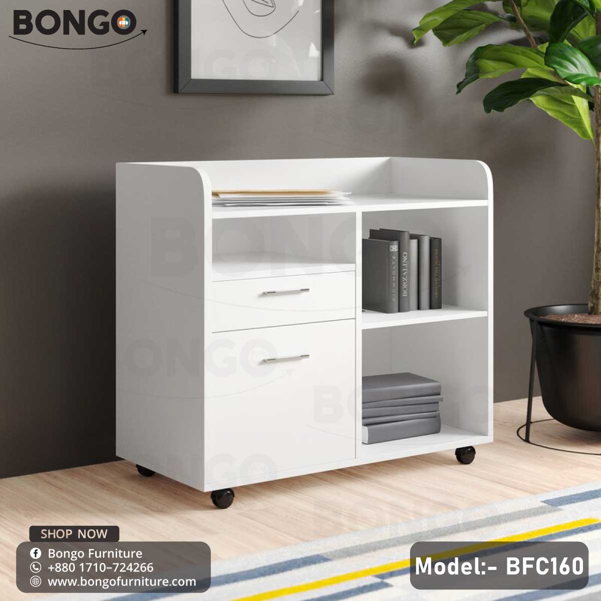 A white Enigma Drawer Unit with model number BFC160, featuring a single drawer and a lower shelf, set against a background of a living room with a potted plant and decorative items.