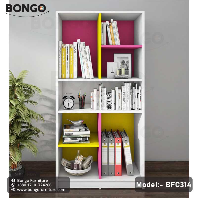 A modern white bookshelf from BONGO, featuring a playful, color-blocked design with bright magenta and yellow back panels and a central divider. The bookcase has an asymmetrical layout of open shelves, which are staged with books, binders, and decorative objects.