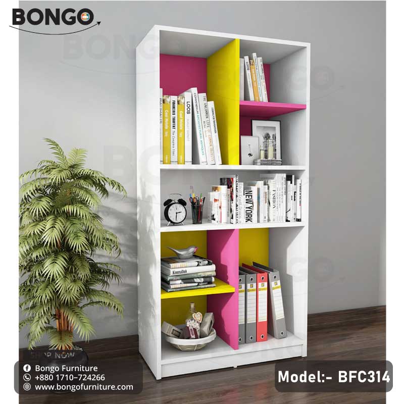 A modern white bookshelf from BONGO, featuring a playful, color-blocked design with bright magenta and yellow back panels and a central divider. The bookcase has an asymmetrical layout of open shelves, which are staged with books, binders, and decorative objects.