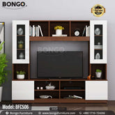 A brown and white monitor TV shelf with glass doors and various decorative items, a TV is placed on the shelf with a plant and books around it.