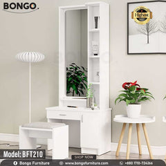 A white polished dressing table with a mirror, model BFT210, displayed in a room setting with decorative items and a plant beside it. A white polished dressing table with a mirror, model BFT210, displayed in a room setting with decorative items and a plant beside it.