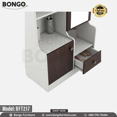 A white and brown Maven Dressing Table with a mirror, model BFT217, displayed in a room with various clothes and accessories arranged around it. A white and brown Maven Dressing Table with a mirror, model BFT217, displayed in a room with various clothes and accessories arranged around it.