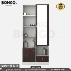 A white and brown Maven Dressing Table with a mirror, model BFT217, displayed in a room with various clothes and accessories arranged around it. A white and brown Maven Dressing Table with a mirror, model BFT217, displayed in a room with various clothes and accessories arranged around it.