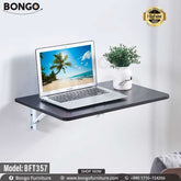 A wall-mounted desk with a black steel frame and a laminated board top, featuring a laptop and a potted plant on it, against a white wall.