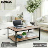 A black steel frame pours tea table with a wooden tabletop, model BFT508, placed in a living room setting with a laptop, books, and a plant on top.