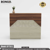 A guest reception desk with a laminated board top in beige color and a wood-like finish on the top, accompanied by a lower shelf in gray. The desk has a drawer unit and a locking mechanism, intended for office furniture.