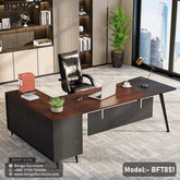 A Dynasty Boss Table model BFT851 with a black steel frame and a brown laminated tabletop, featuring a desk setup with office chairs and decorative plants in the background.