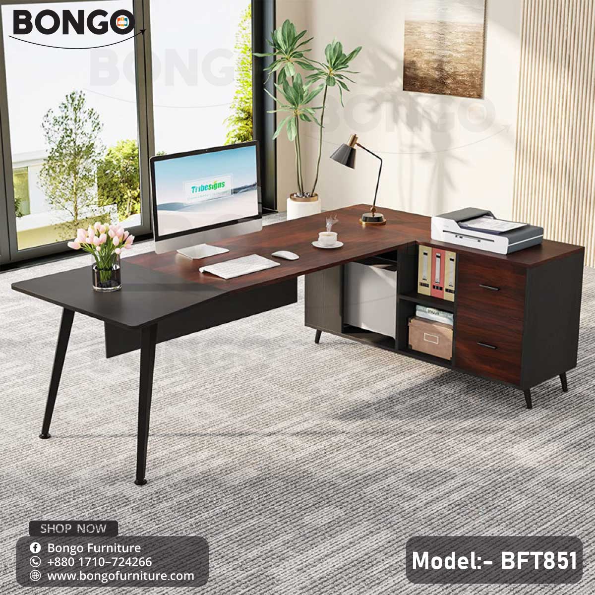 A Dynasty Boss Table model BFT851 with a black steel frame and a brown laminated tabletop, featuring a desk setup with office chairs and decorative plants in the background.