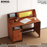 A brown study table with a cork board, white board for notes, and a storage cabinet, branded by BONGO, with a phone, books, and a mug on top.
