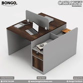 A modern two-person workstation with dark Water Resistant Strong Laminated Board desktops and a light gray frame. The back-to-back design features a central storage spine and an attached side unit with a lockable drawer and cabinet. A low, light gray privacy screen separates the two work areas, which are staged with a laptop and office supplies.