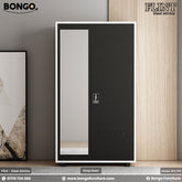 A black steel almirah with a mirror door, positioned against a wall with a painting to the left, on a wooden floor.