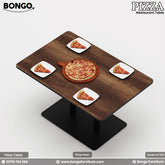 A modern restaurant booth setup, including a rectangular table and two high-backed, facing benches. The benches are upholstered in a dark gray fabric with vertical channel tufting. The table has a dark Water Resistant Strong Laminated Board top and a black pedestal base. The scene is set for a meal, with a large pizza and drinks arranged on the table.