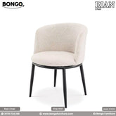 A modern barrel-style dining chair upholstered in a textured, off-white boucle fabric. The chair features a curved, enclosing backrest and arms, and is supported by four tapered, matte black legs that angle outwards.