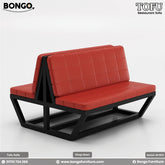 A promotional image of the 'TOFU Restaurant Sofa' from BONGO. The set includes two modern benches and a square table. The benches feature an angular black metal frame and bright red, quilted leather-style cushions. The central table has a dark wood-grain top and a black pedestal base.