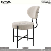 A contemporary chair with a beige boucle fabric seat and a distinctive curved backrest, supported by a frame of heavy-duty mild steel with zinc phosphate and powder coating.