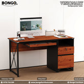 A Granada Pine and Black Visionary Multi Tasking Table with a computer monitor, keyboard, and a notebook on it, set against a white background.