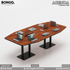 A conference room setting featuring the Agenda Conference Table with a dark Water Resistant Strong Laminated Board finish, accompanied by black office chairs and laptops on the table.