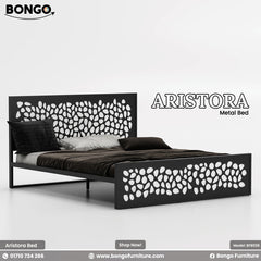 A promotional image of the "ARISTORA Metal Bed" by Bongo. The modern bed frame is made of black metal and features a distinctive decorative design. Both the tall, rectangular headboard and the matching lower footboard have a laser-cut pattern of organic, leaf-like or pebble shapes. The bed is made with dark brown and grey bedding and is set against a plain, light grey background.