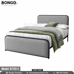 A full size bed with a gray headboard and footboard, featuring a white mattress, placed in a room with nightstands and wall art.