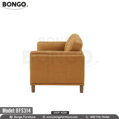 A modern two-seater loveseat upholstered in a smooth, tan-colored leather. The sofa's distinctive features include wide arms with vertical channel tufting on the exterior and tapered, light-colored legs. It is staged with two throw pillows and is pictured in a living room on a dark blue patterned rug.
