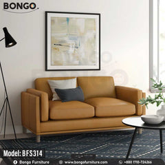 A modern two-seater loveseat upholstered in a smooth, tan-colored leather. The sofa's distinctive features include wide arms with vertical channel tufting on the exterior and tapered, light-colored legs. It is staged with two throw pillows and is pictured in a living room on a dark blue patterned rug.
