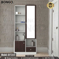 A white and brown Maven Dressing Table with a mirror, model BFT217, displayed in a room with various clothes and accessories arranged around it.