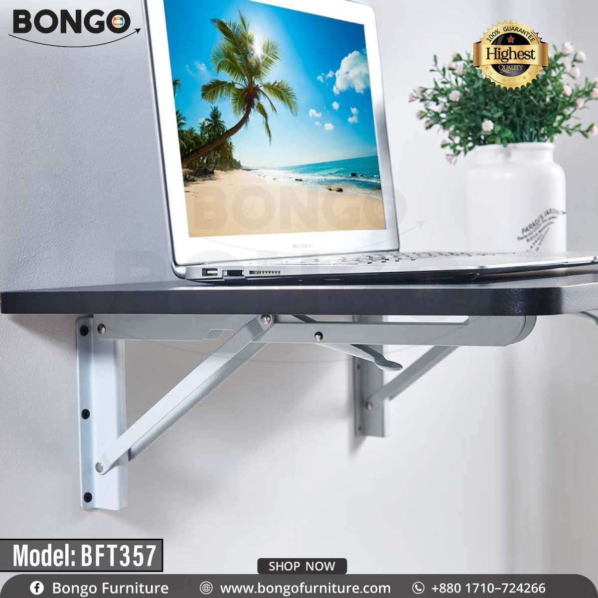 A wall-mounted desk with a black steel frame and a laminated board top, featuring a laptop and a potted plant on it, against a white wall.