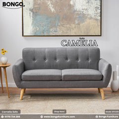 Gray sofa named 'Camelia' by Bongo Furniture in a room setting with decor elements.