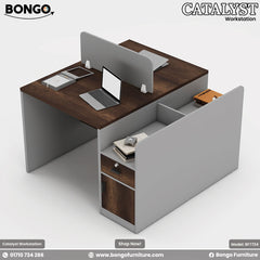 A modern two-person workstation with dark Water Resistant Strong Laminated Board desktops and a light gray frame. The back-to-back design features a central storage spine and an attached side unit with a lockable drawer and cabinet. A low, light gray privacy screen separates the two work areas, which are staged with a laptop and office supplies.