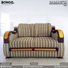 A Jamaica sofa with a striped fabric upholstery, wooden frame with golden accents, and golden detailed legs.