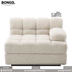 A beige Fila sofa with a modern design, featuring plush foam and a round footstool, displayed against a white background.