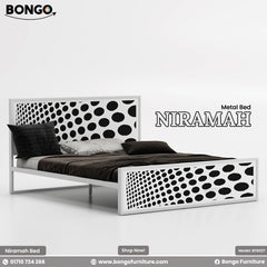 A promotional image of the "NIRAMAH Metal Bed" by Bongo, presented in a high-contrast black and white graphic design. The modern metal bed frame is finished in solid white. The tall, rectangular headboard and matching lower footboard feature a bold pattern of black circles on a white background. The circles gradually increase in size from one side to the other, creating a dynamic gradient or optical illusion effect. The bed is styled with dark grey and brown bedding.