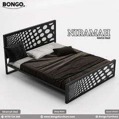 A promotional image of the "NIRAMAH Metal Bed" by Bongo. The modern bed frame is constructed from black metal and features a distinctive design. Both the tall, rectangular headboard and the matching lower footboard have a decorative laser-cut pattern of circles that gradually increase in size from left to right, creating a gradient polka-dot effect. The bed is styled with dark brown and grey bedding and is set against a plain, light grey background.
