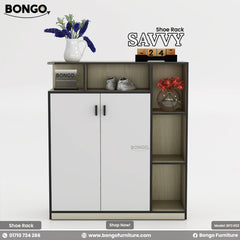 A product photo of a modern storage cabinet or console. The cabinet has a Albino color Water Resistant Strong Laminated Board frame, two central white doors with black trim and handles, and a column of three open shelves on the right. A long, open shelf runs across the top of the unit. The shelves are styled with decorative items, including a vase of purple flowers, a pair of sneakers, a wooden block calendar, and another small vase with red flowers. The brand name "BONGO" is visible on the unit.