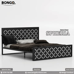 A product photo of the "SPHERIA Metal Bed," model BFB028, from Bongo Furniture. The slate grey bed is shown in a bright bedroom setting and is distinguished by the intricate, repeating quatrefoil cutout pattern on its.