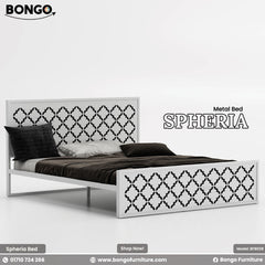 A product photo of the "SPHERIA Metal Bed," model BFB028, from Bongo Furniture. The slate grey bed is shown in a bright bedroom setting and is distinguished by the intricate, repeating quatrefoil cutout pattern on its.