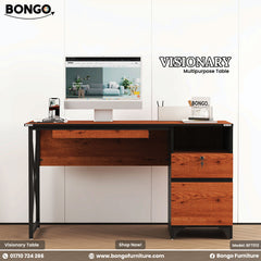 A Granada Pine and Black Visionary Multi Tasking Table with a computer monitor, keyboard, and a notebook on it, set against a white background.